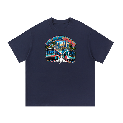 We Move Miami Tee — navy heavyweight cotton with the MIA transit badge featuring the Miami skyline, Metromover, and bus, printed on the front.